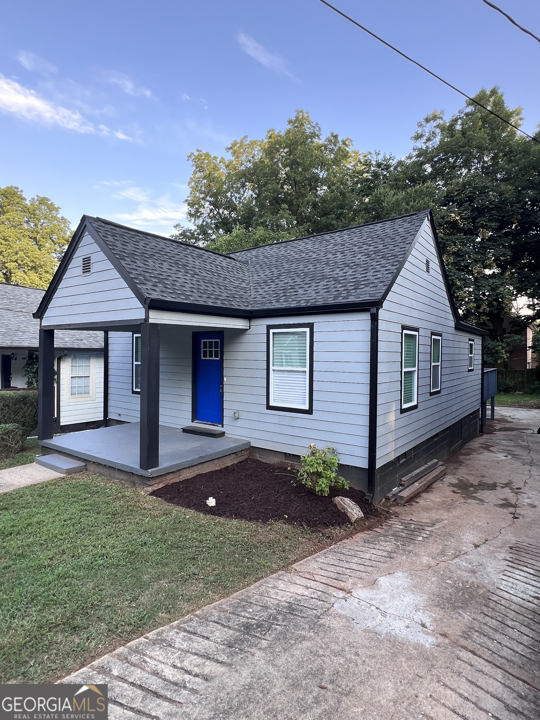 a front view of a house with a garden and yard