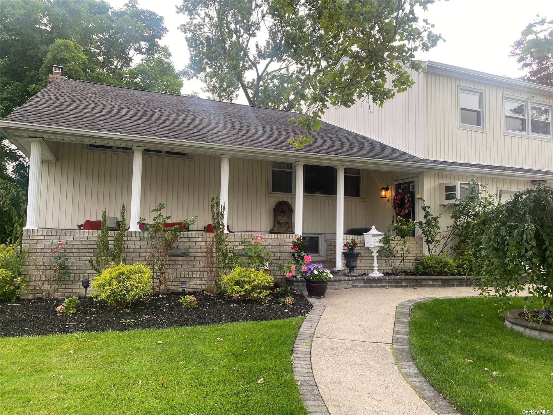 a front view of a house with a yard and potted plants