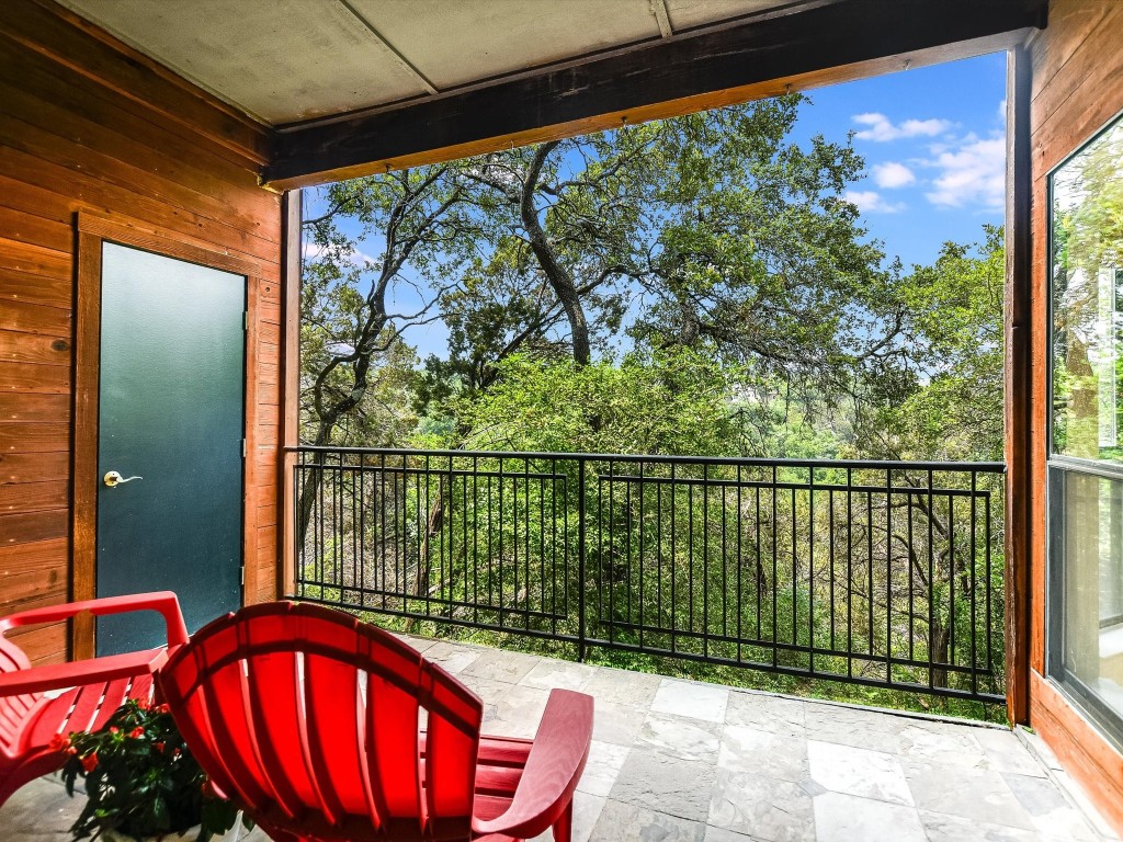 Great covered porch with storage closet and fabulous view into the natural wooded area.
