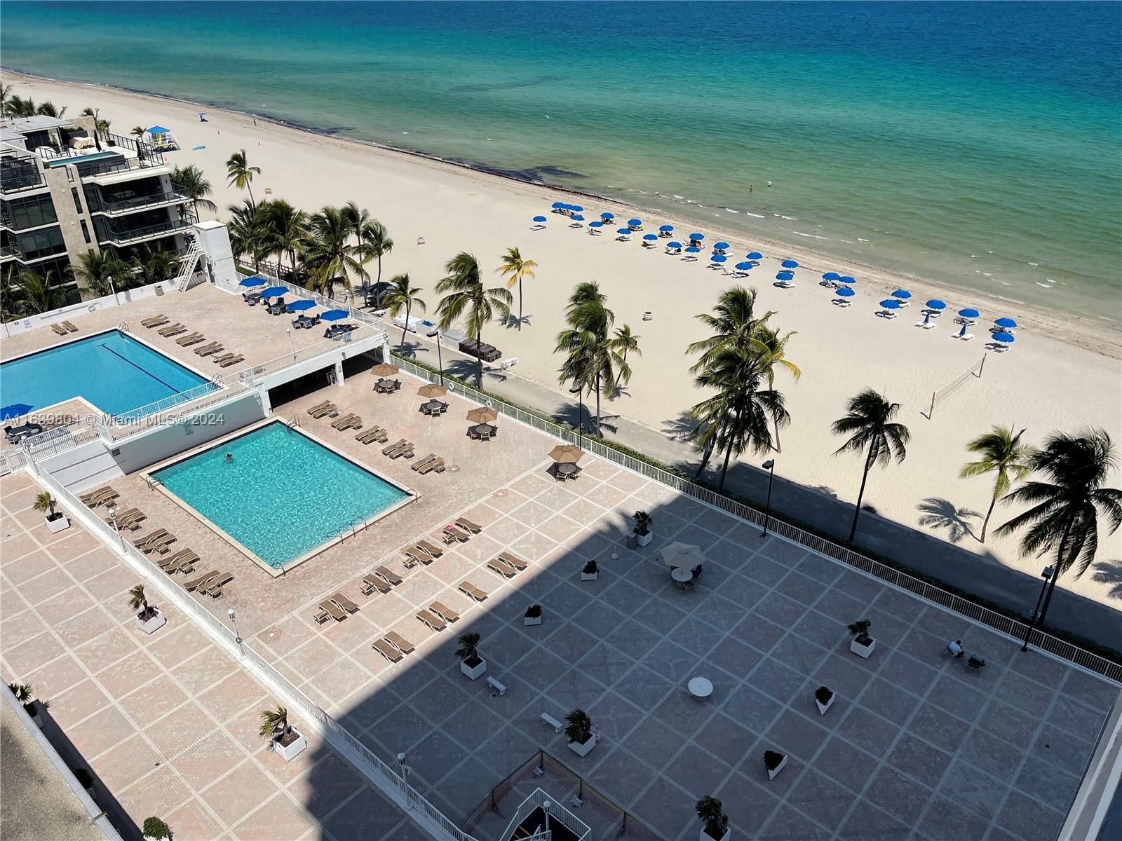 a view of a swimming pool with outdoor seating and flat screen tv