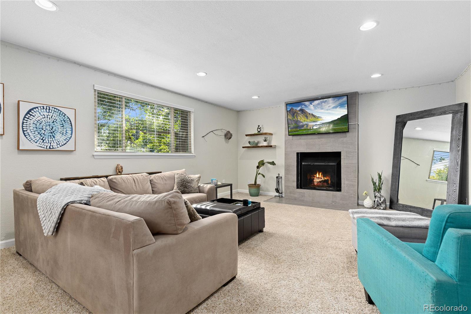 a living room with furniture a large window and a fireplace