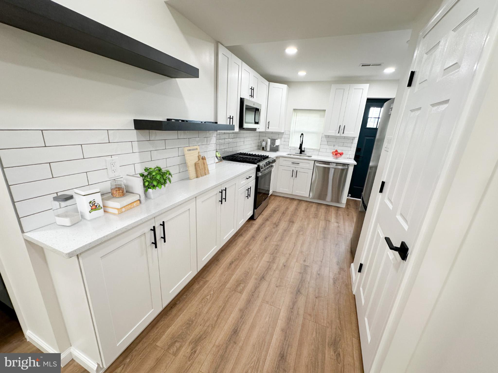 a kitchen with white cabinets sink and refrigerator