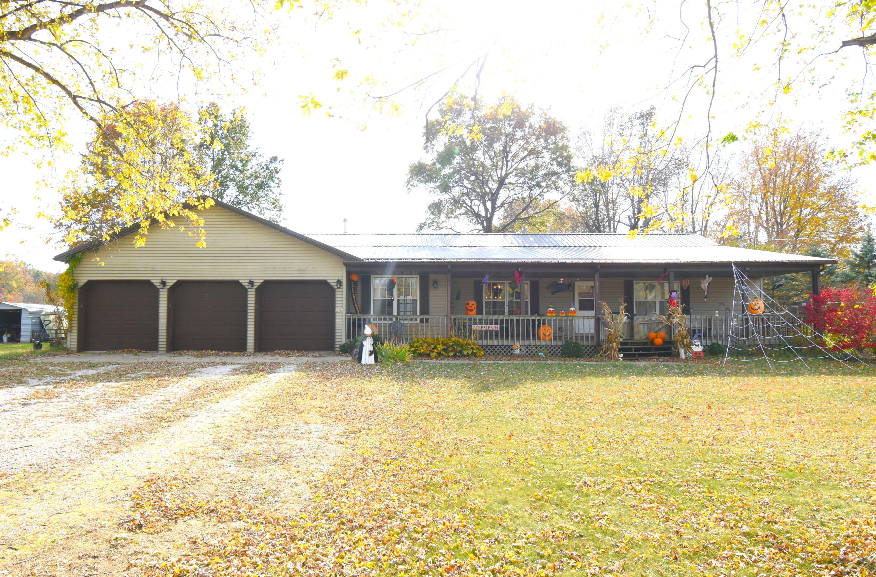 a front view of house with yard and trees in the background