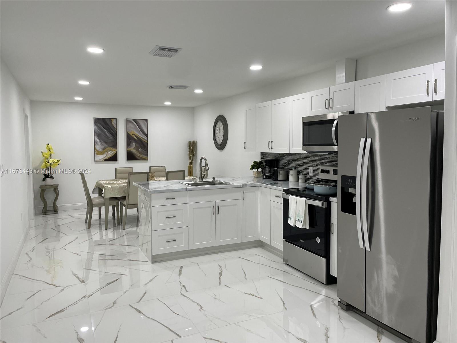 a kitchen with white cabinets and stainless steel appliances