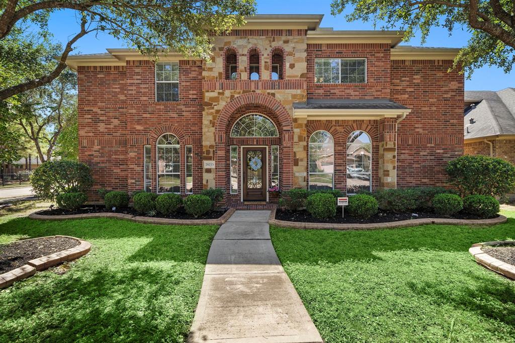 front view of a brick house with a yard