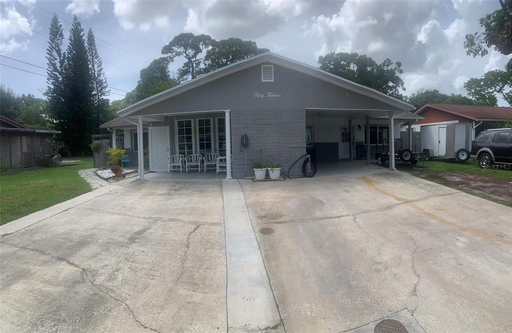 a front view of a house with a garden and trees