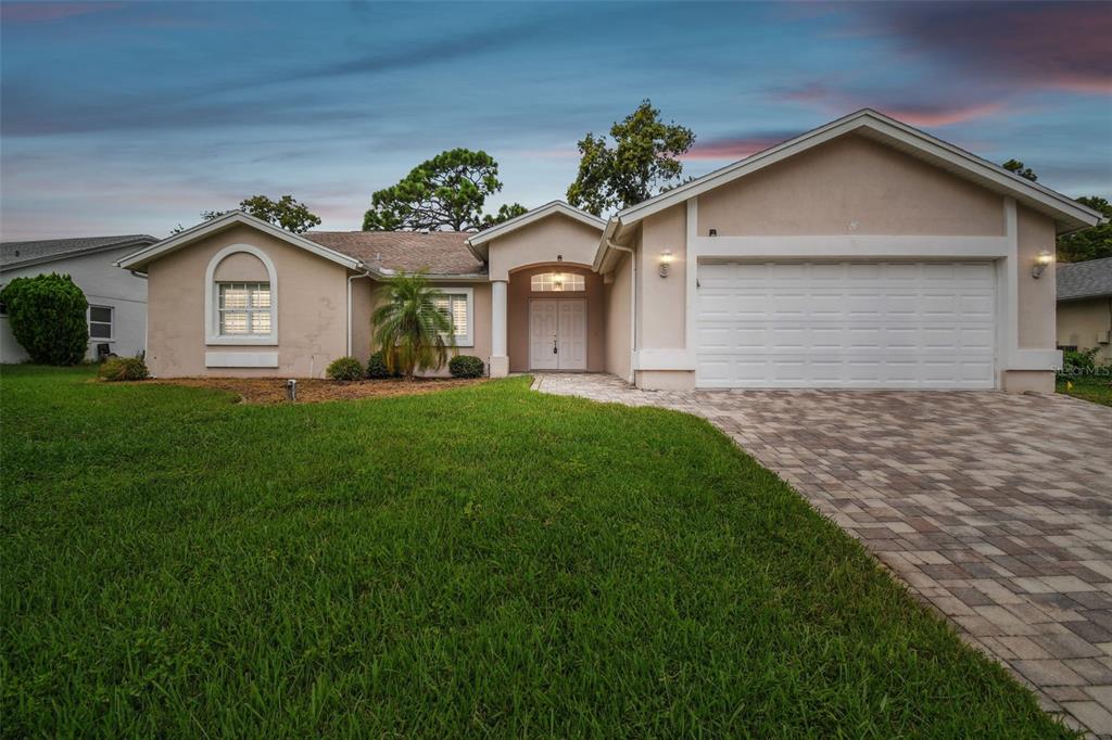 a front view of a house with a garden and yard