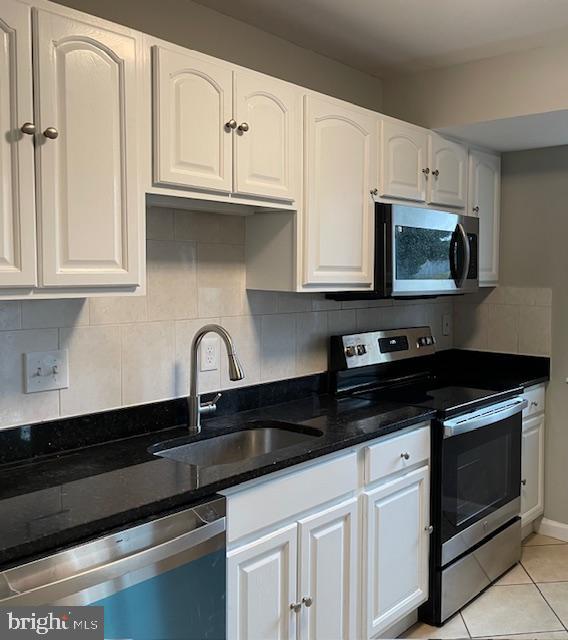 a kitchen with granite countertop white cabinets and black appliances