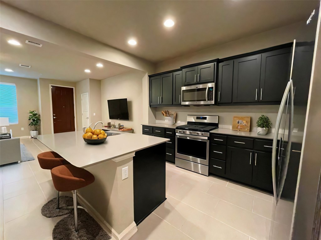 a kitchen with stainless steel appliances kitchen island granite countertop a sink wooden cabinets and a granite counter tops