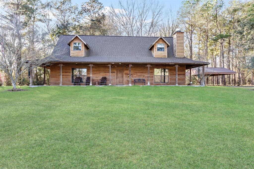 a view of a big house with a big yard and large trees