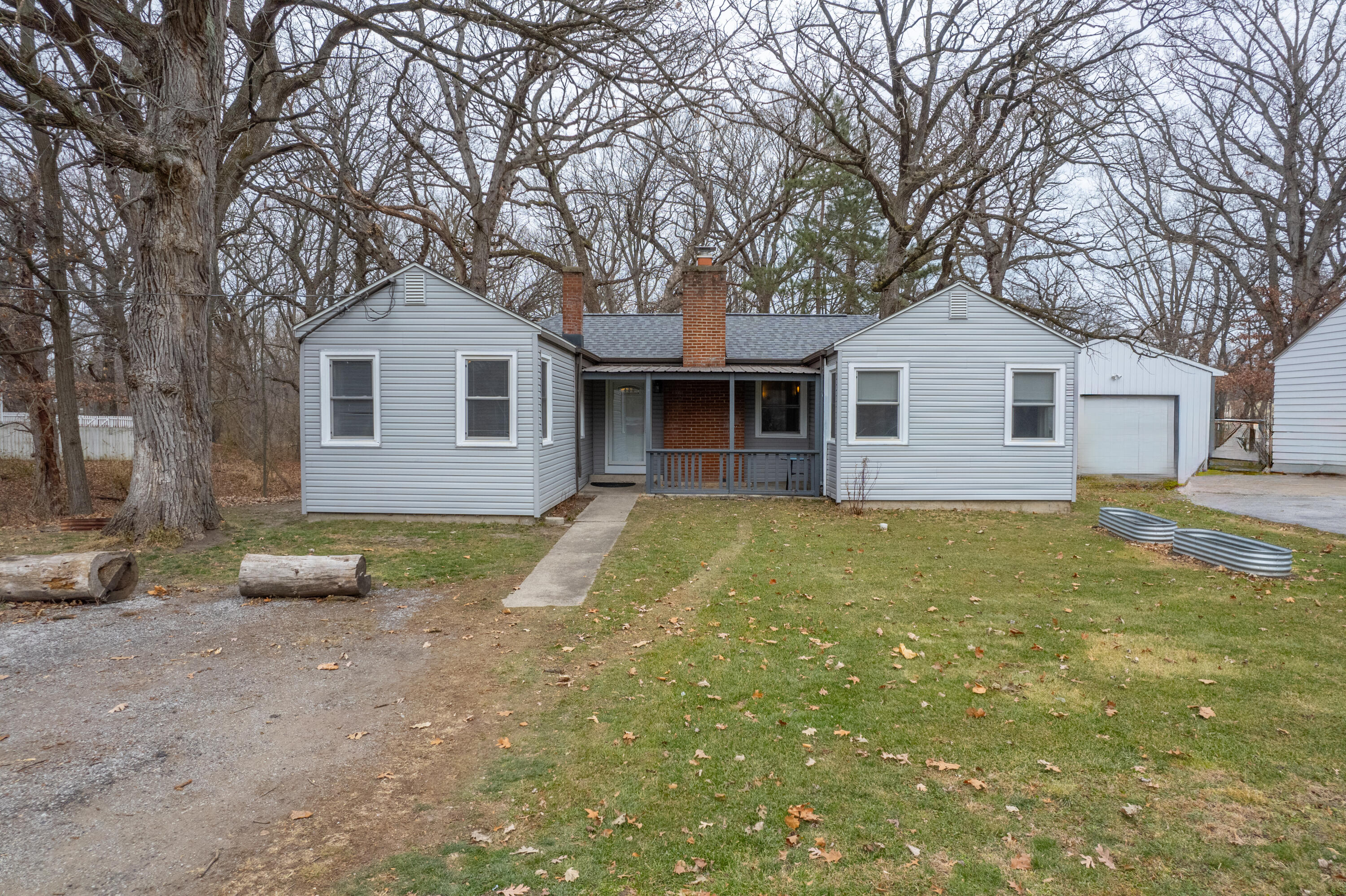 a view of a house with a yard and large tree