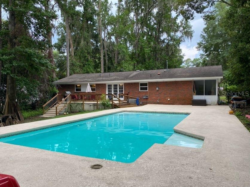 a view of house with swimming pool yard and patio