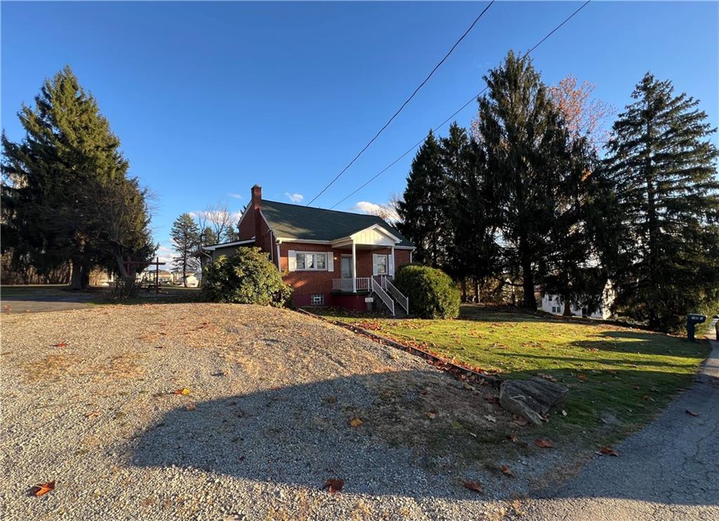 a front view of a house with a yard and trees