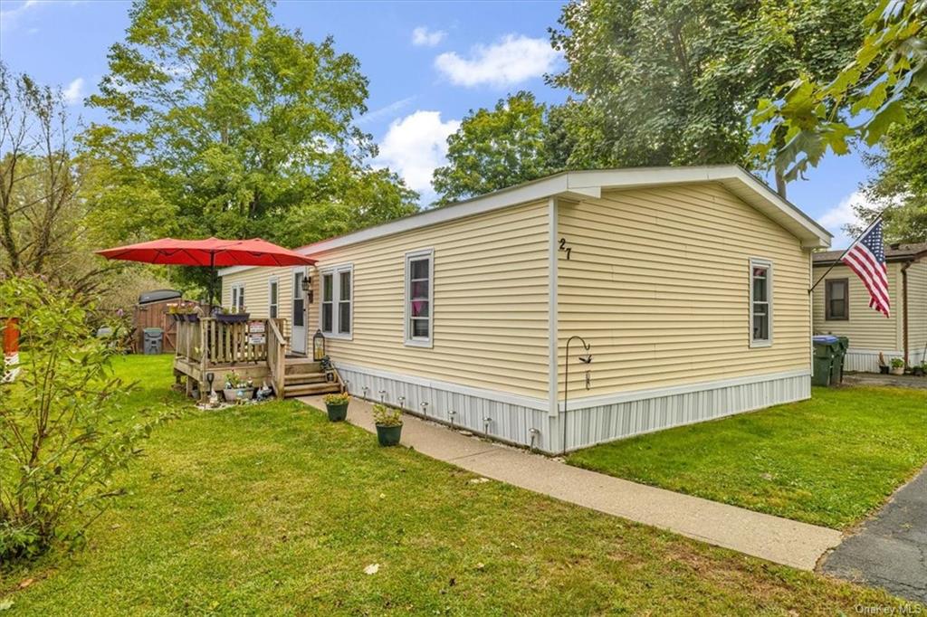 a view of a house with a yard and sitting area