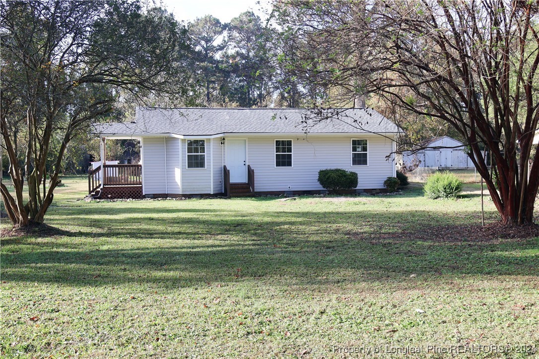 a front view of a house with a garden and trees