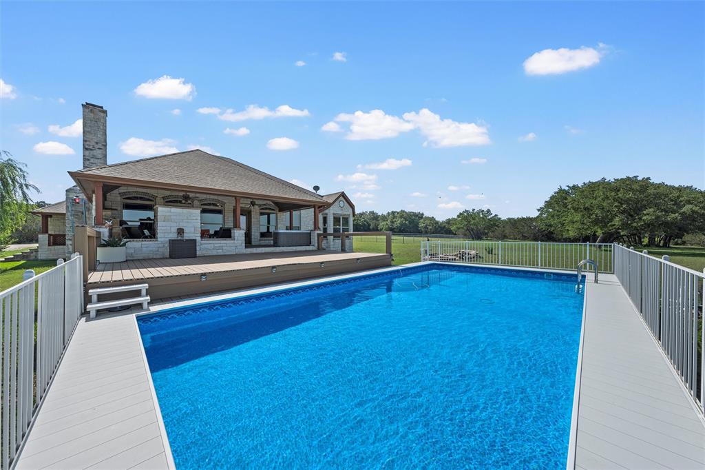 a view of a house with pool and chairs