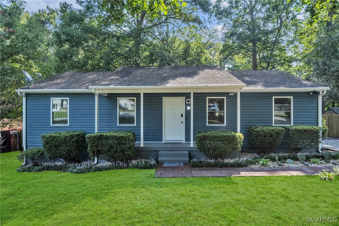 a front view of a house with a yard and plants