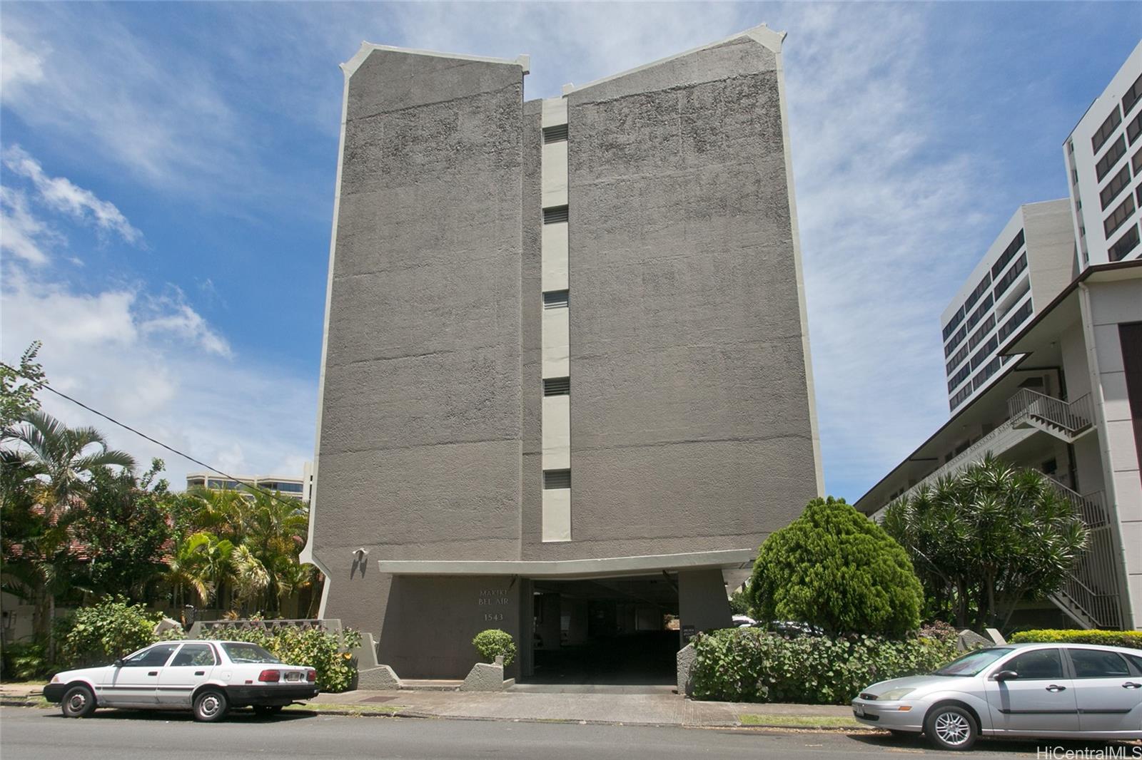 a car parked beside a road next to a building