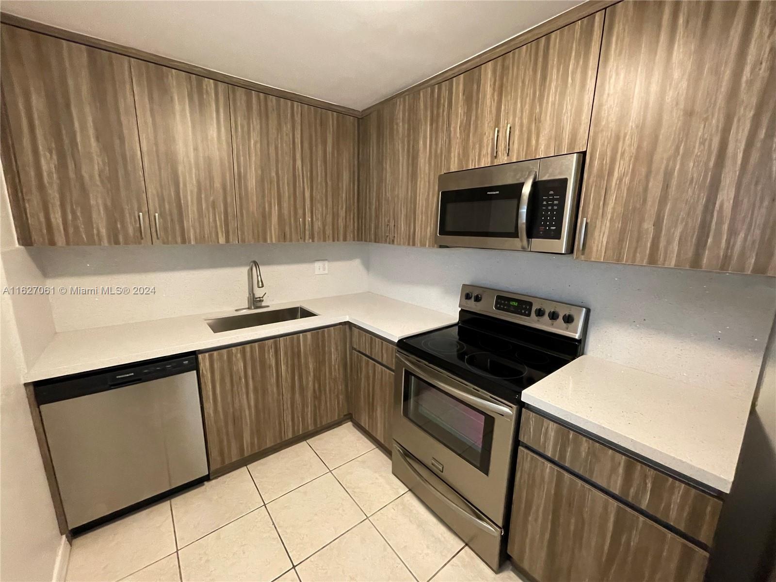 a kitchen with granite countertop wooden cabinets a stove top oven and sink