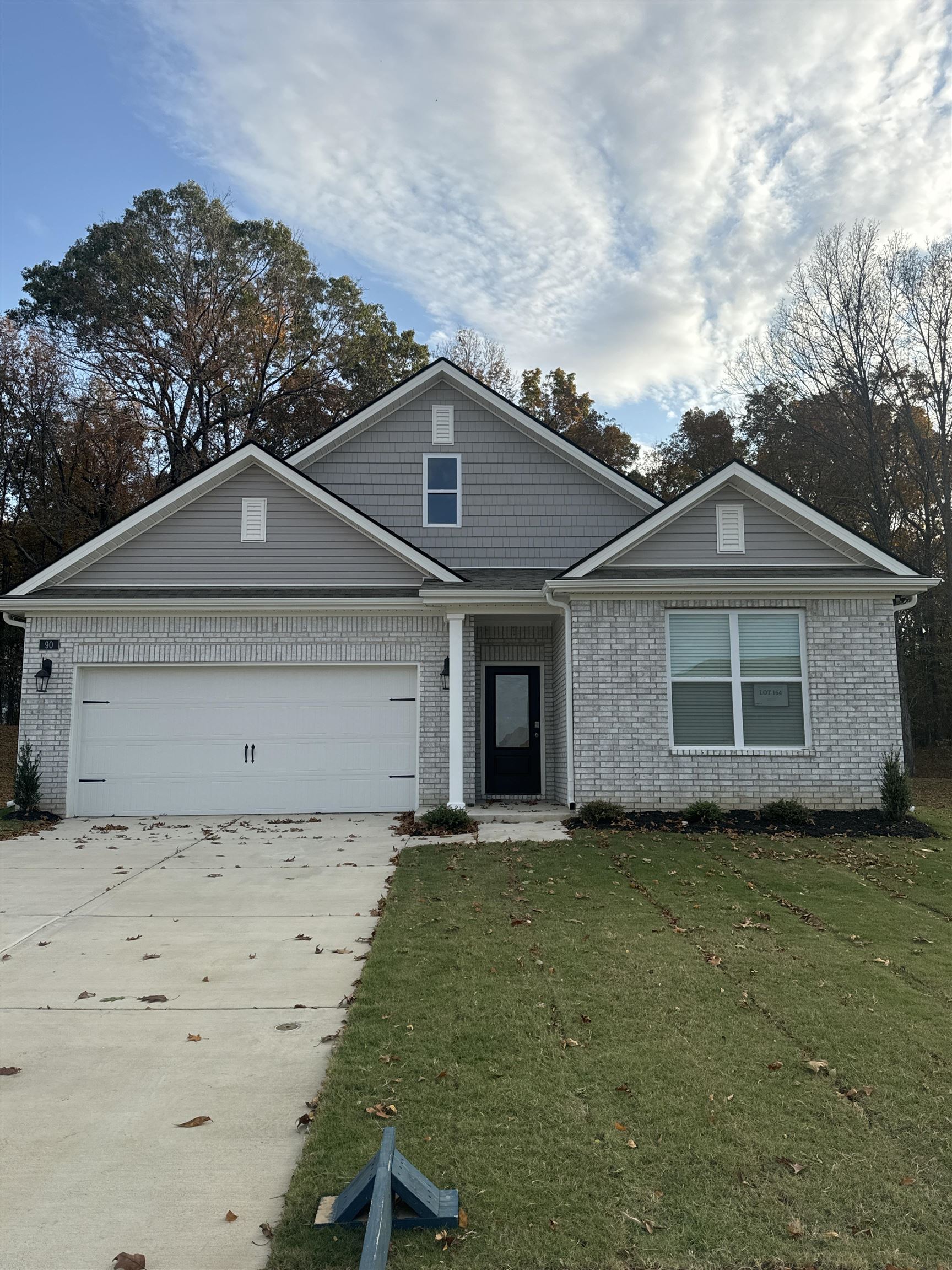 View of front of property with a garage and a front lawn