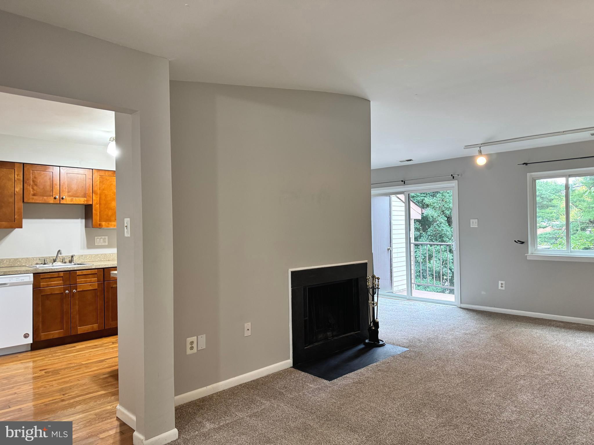 a view of an empty room with a fireplace and a window