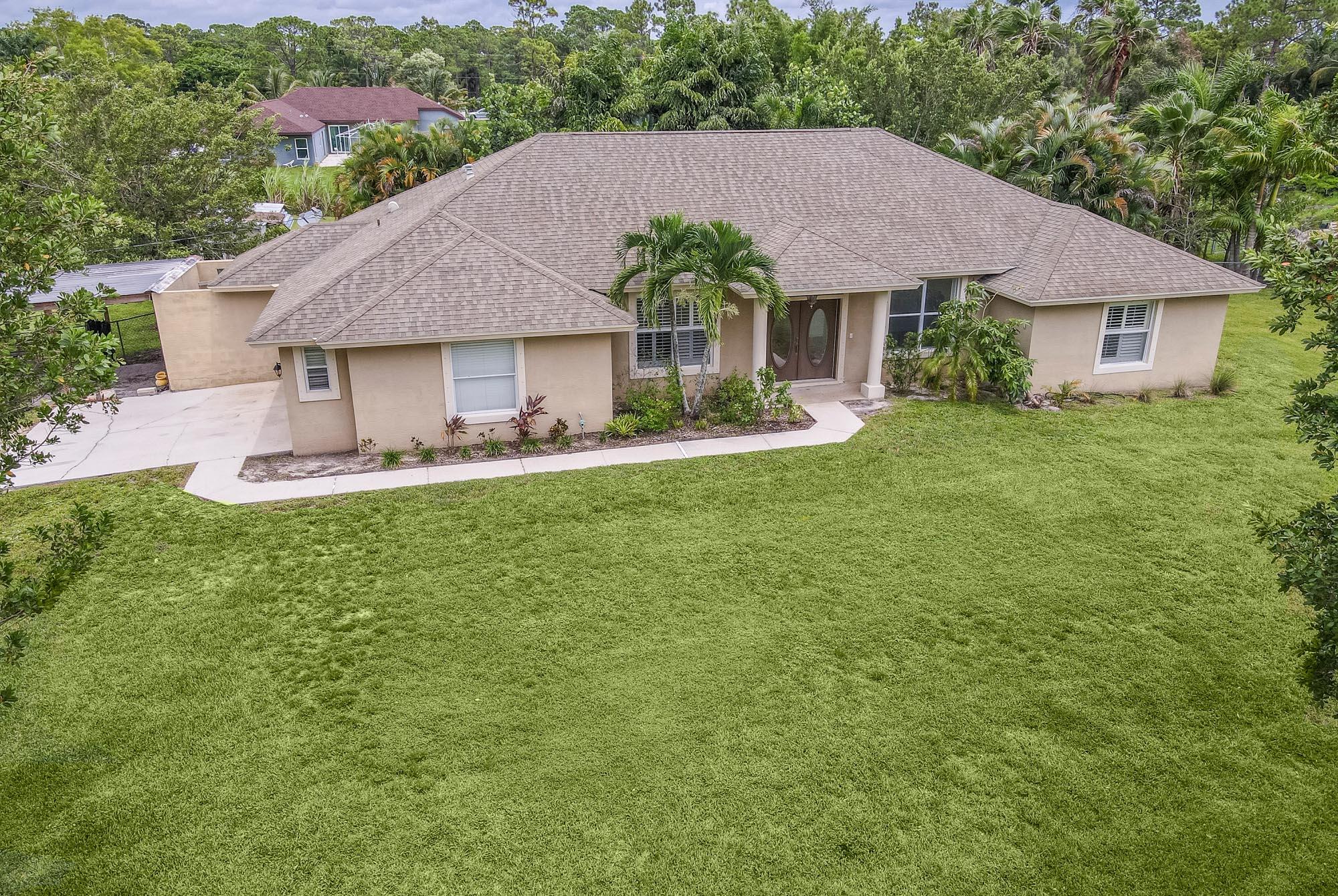 a front view of a house with a garden and yard