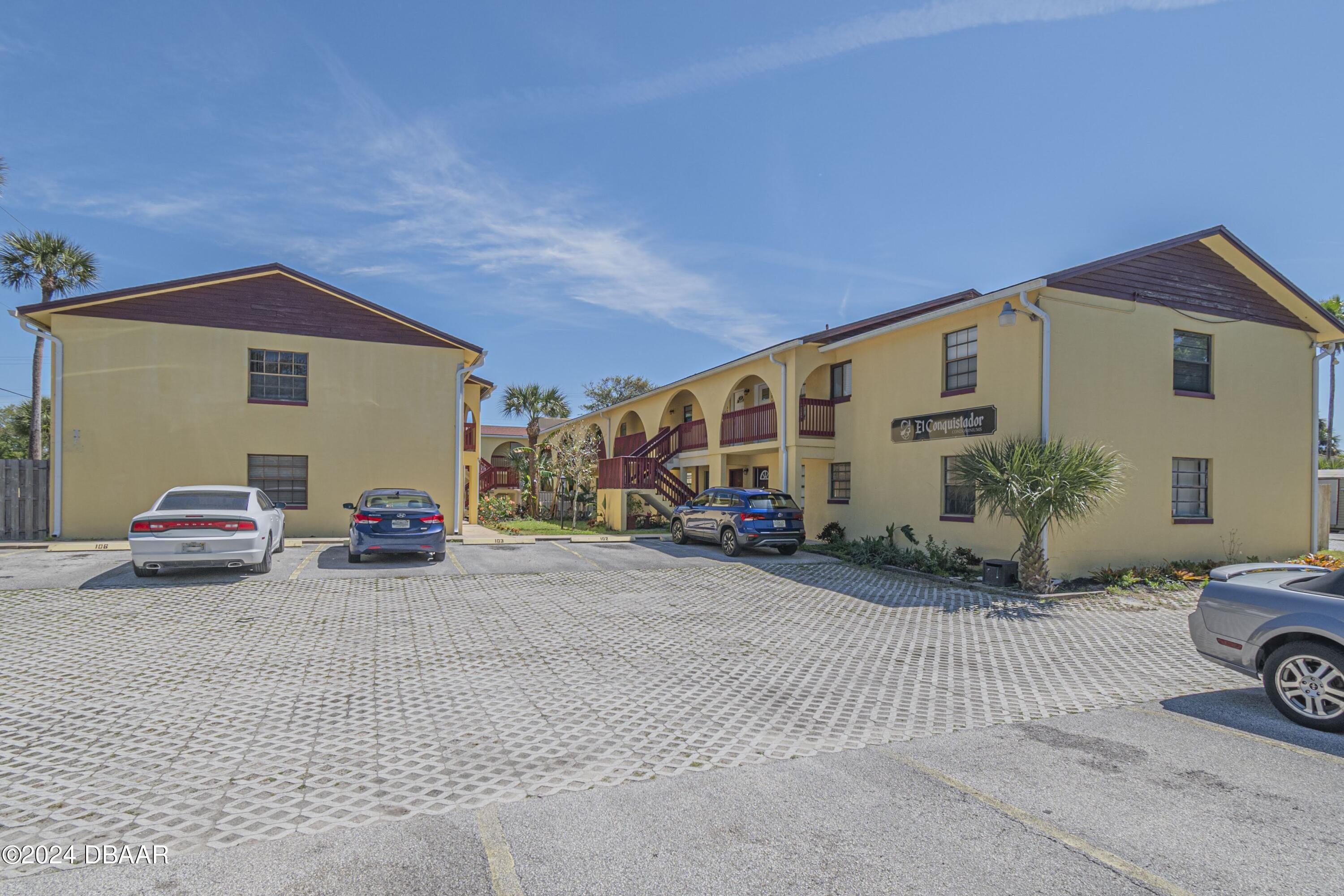 a view of a house with a large space and a car parked beside it