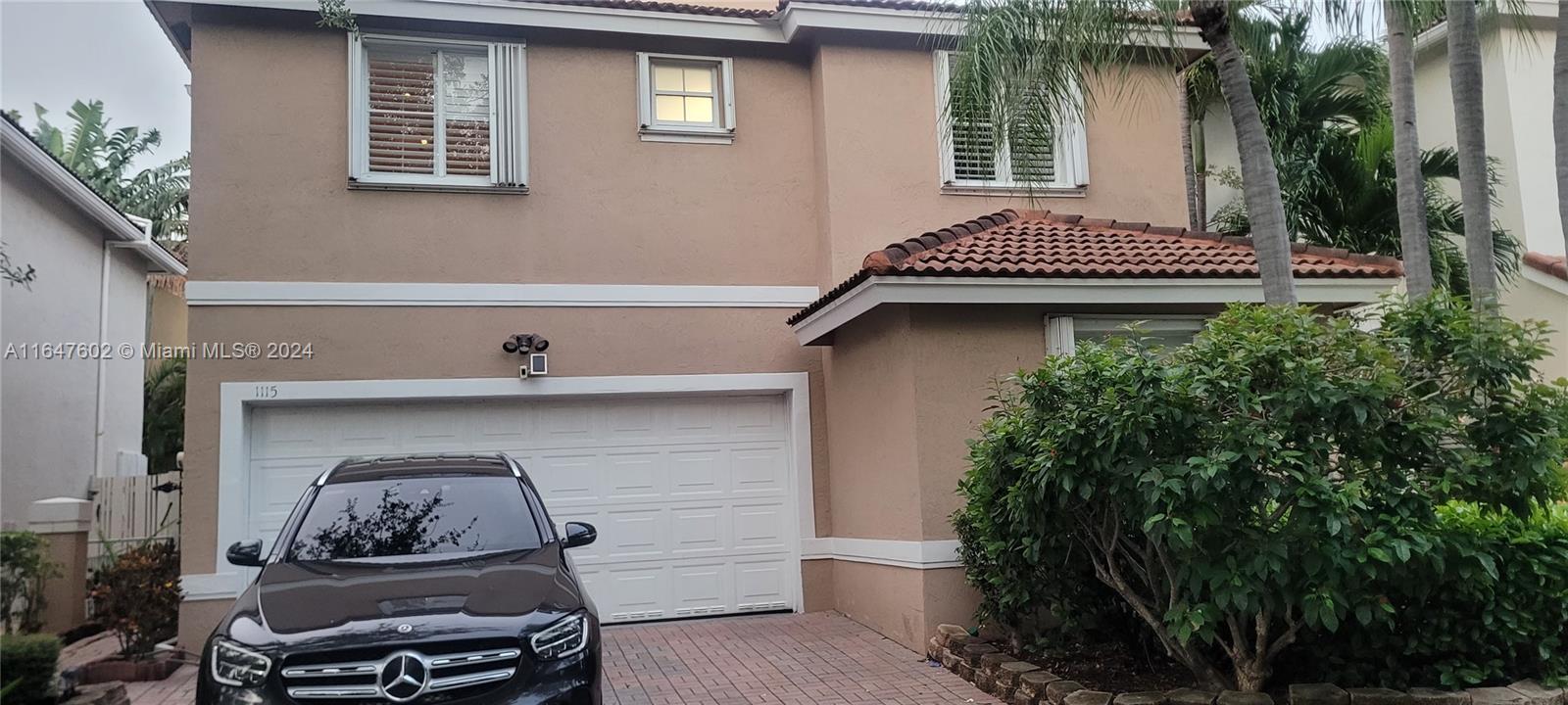 a front view of a house with plants