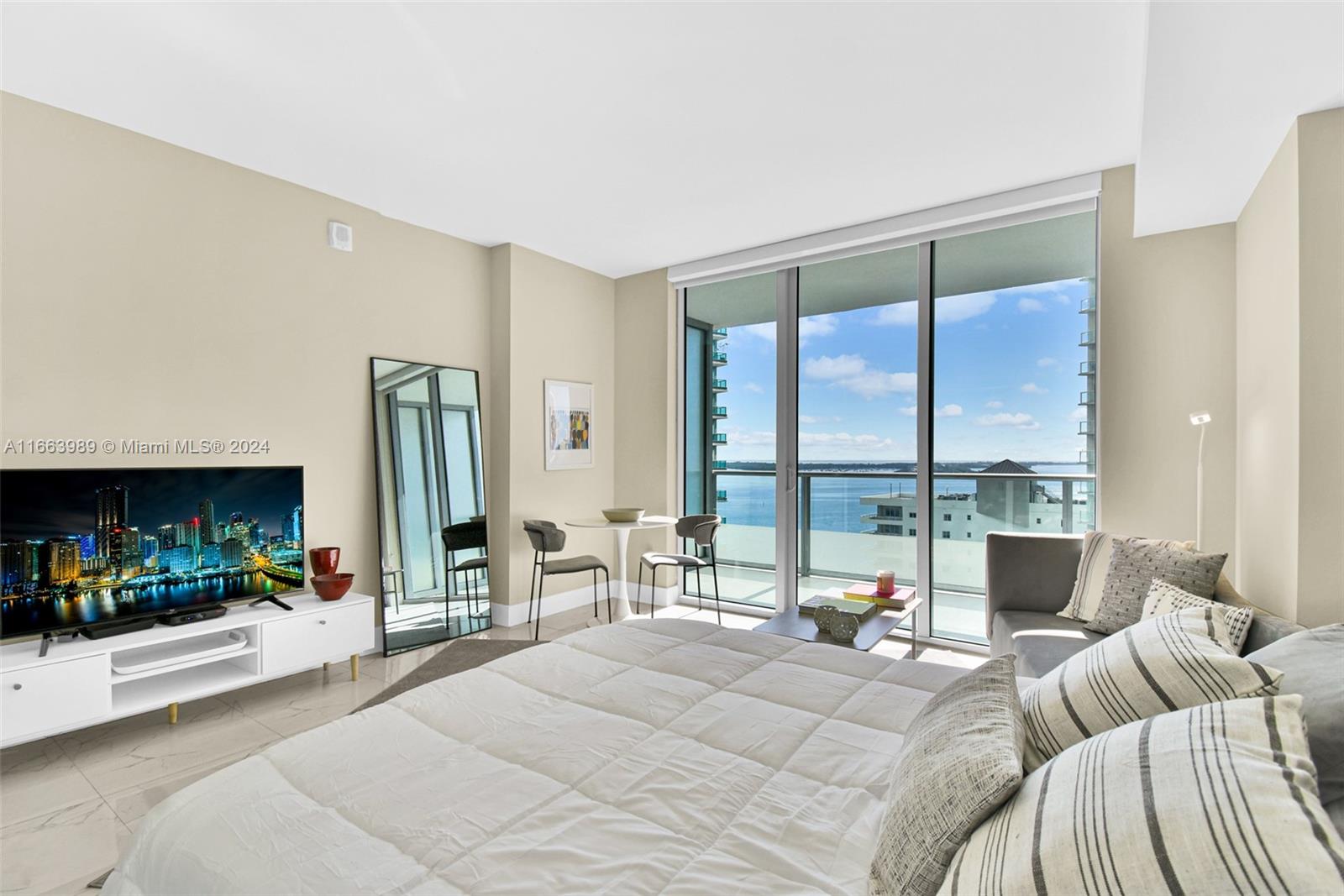 a bedroom with furniture and a large window