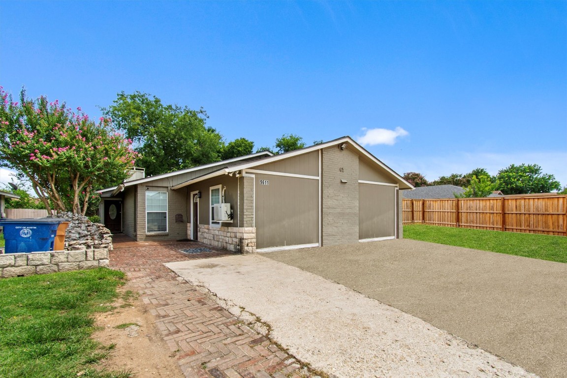 a view of a house with a yard and large tree