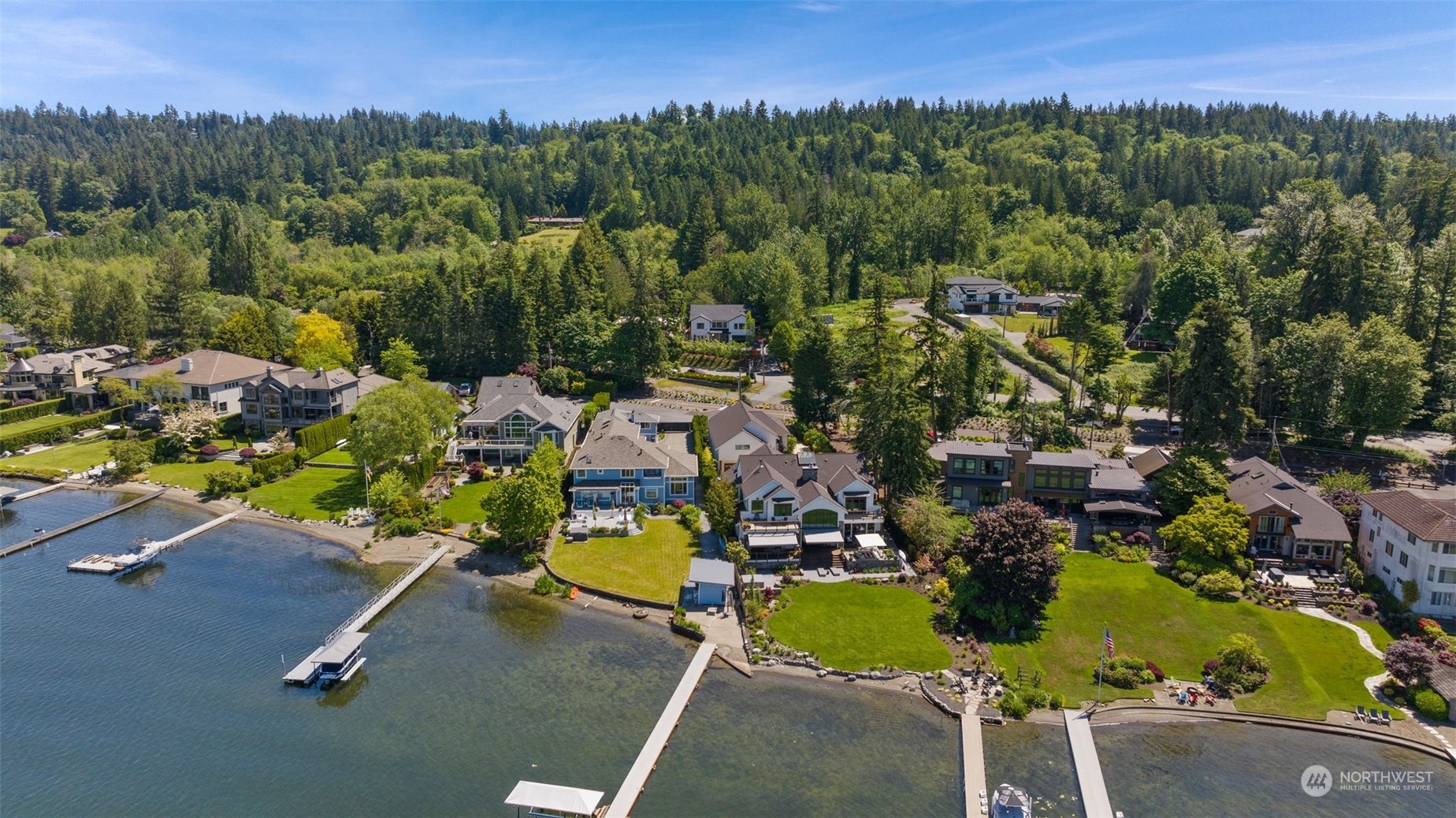 an aerial view of a residential house with swimming pool and outdoor seating