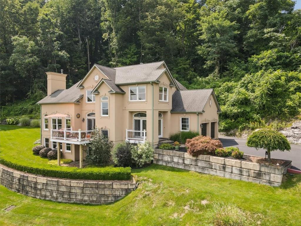 a view of a house with a big yard potted plants and large tree