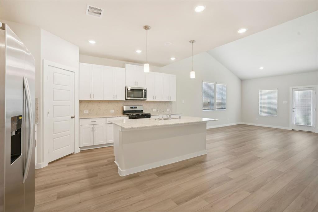 a kitchen with a refrigerator and a stove top oven