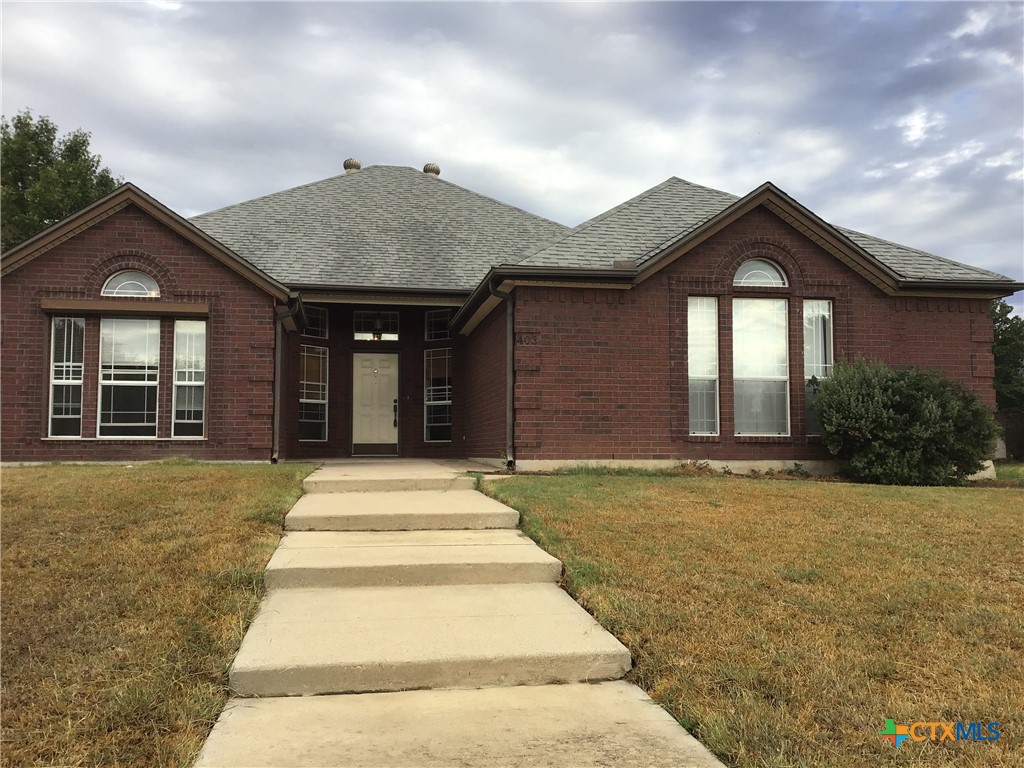 a front view of a house with a garden and yard