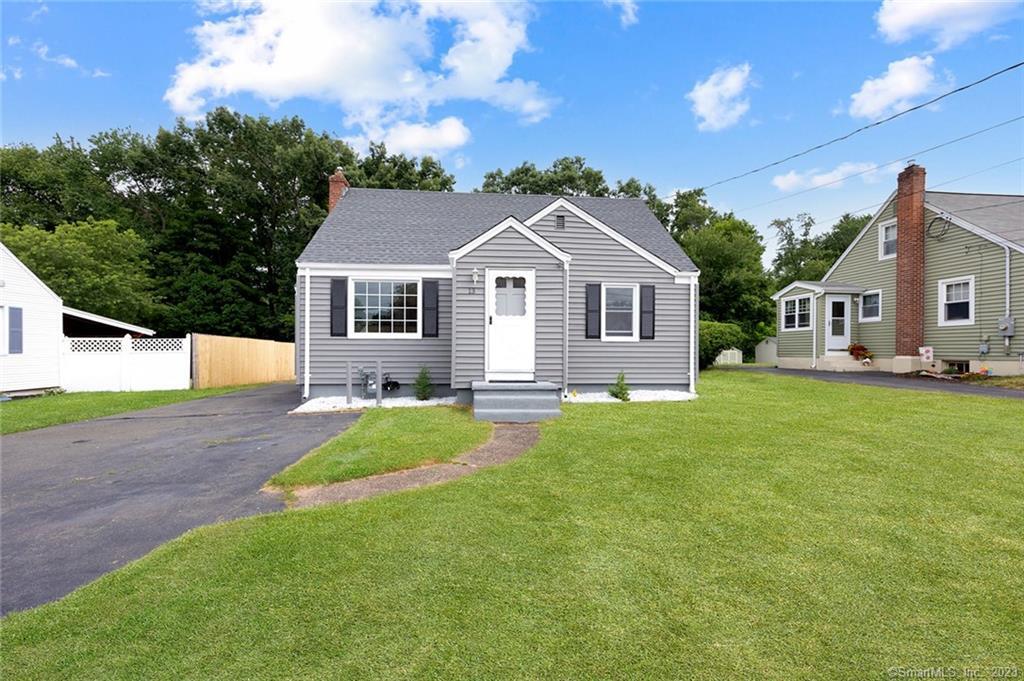 a front view of a house with a garden and yard