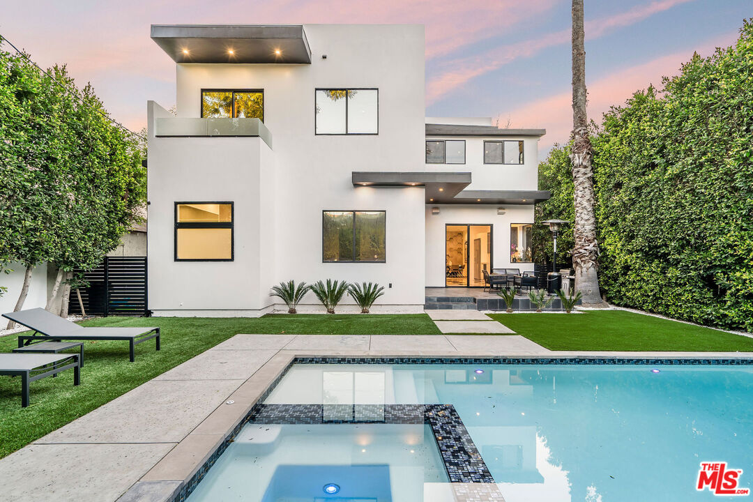 a view of a house with backyard and sitting area