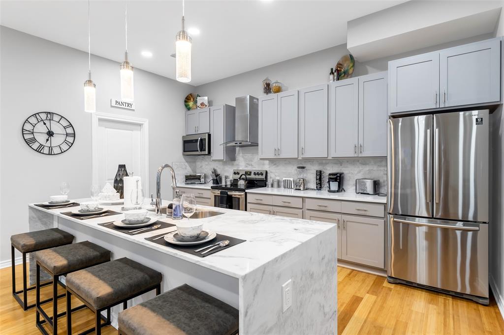 a kitchen with stainless steel appliances a table chairs and a refrigerator