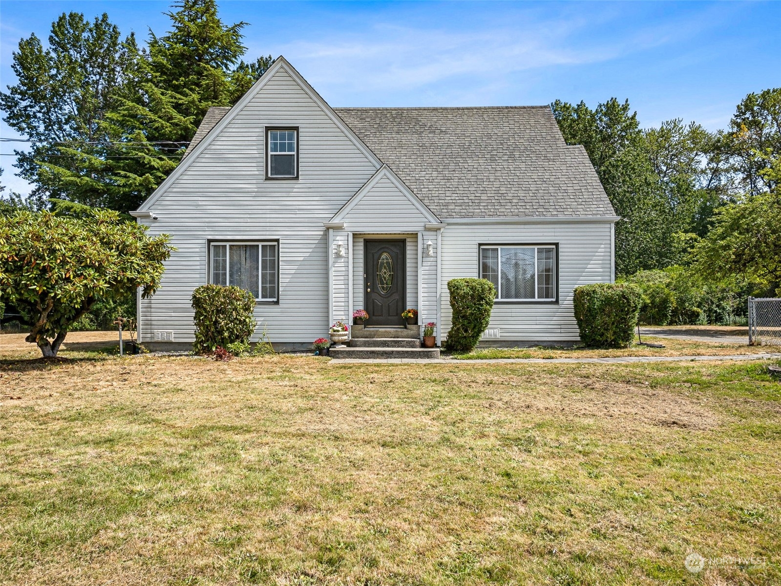 a view of a house with backyard and trees