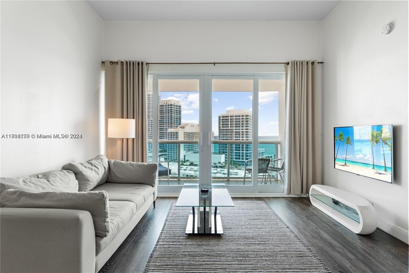 a living room with furniture and a floor to ceiling window