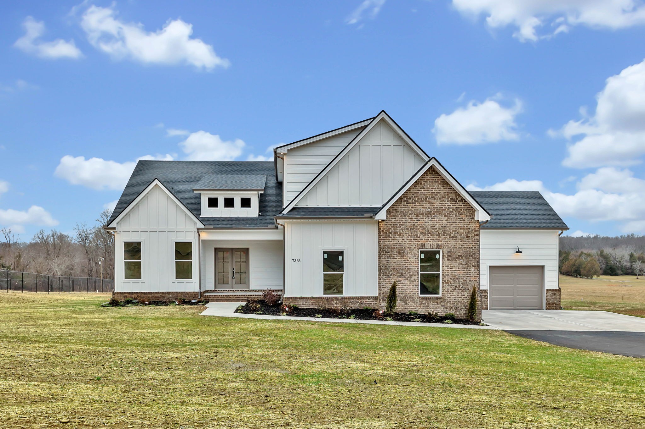 a front view of a house with a garden and yard