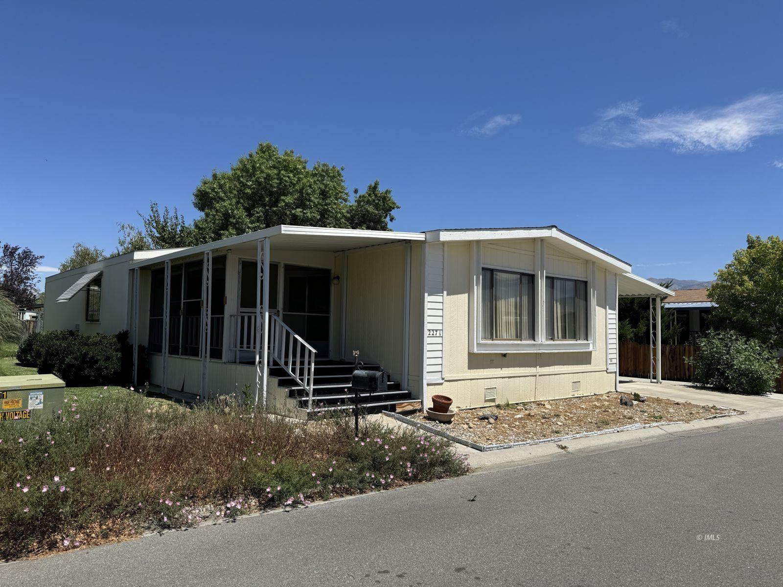 a front view of a house with yard and trees in the background