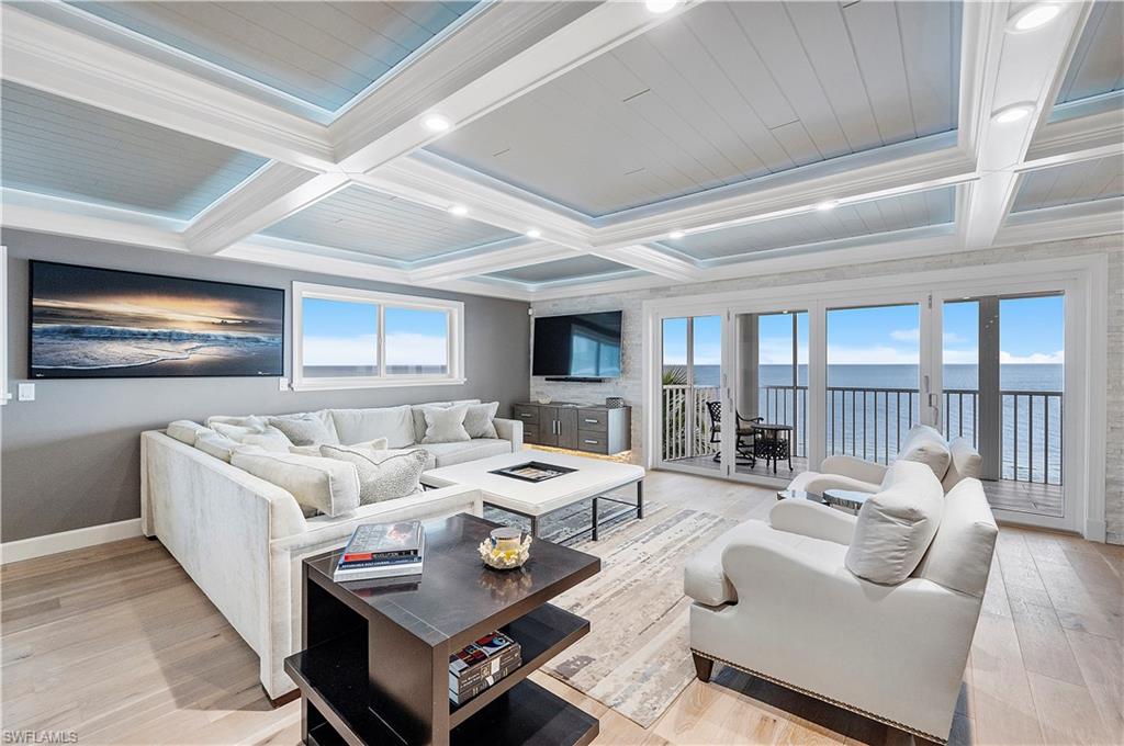 a living room with furniture a flat screen tv and a large window