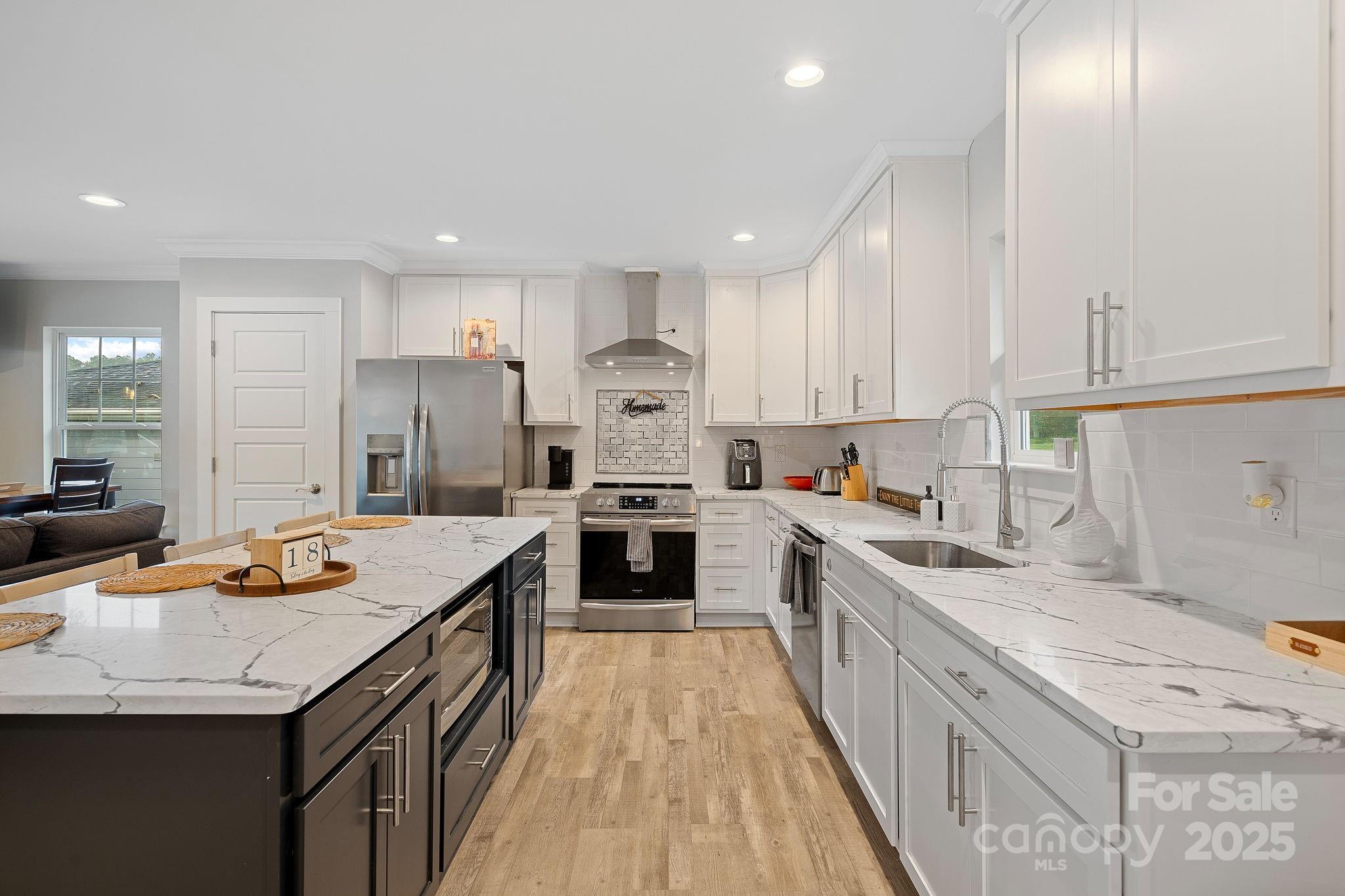 a kitchen with stainless steel appliances granite countertop a sink stove and refrigerator