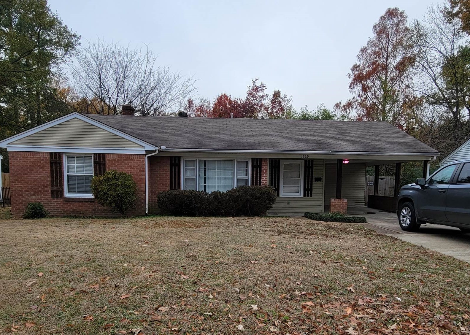 a view of a house with a yard and large tree