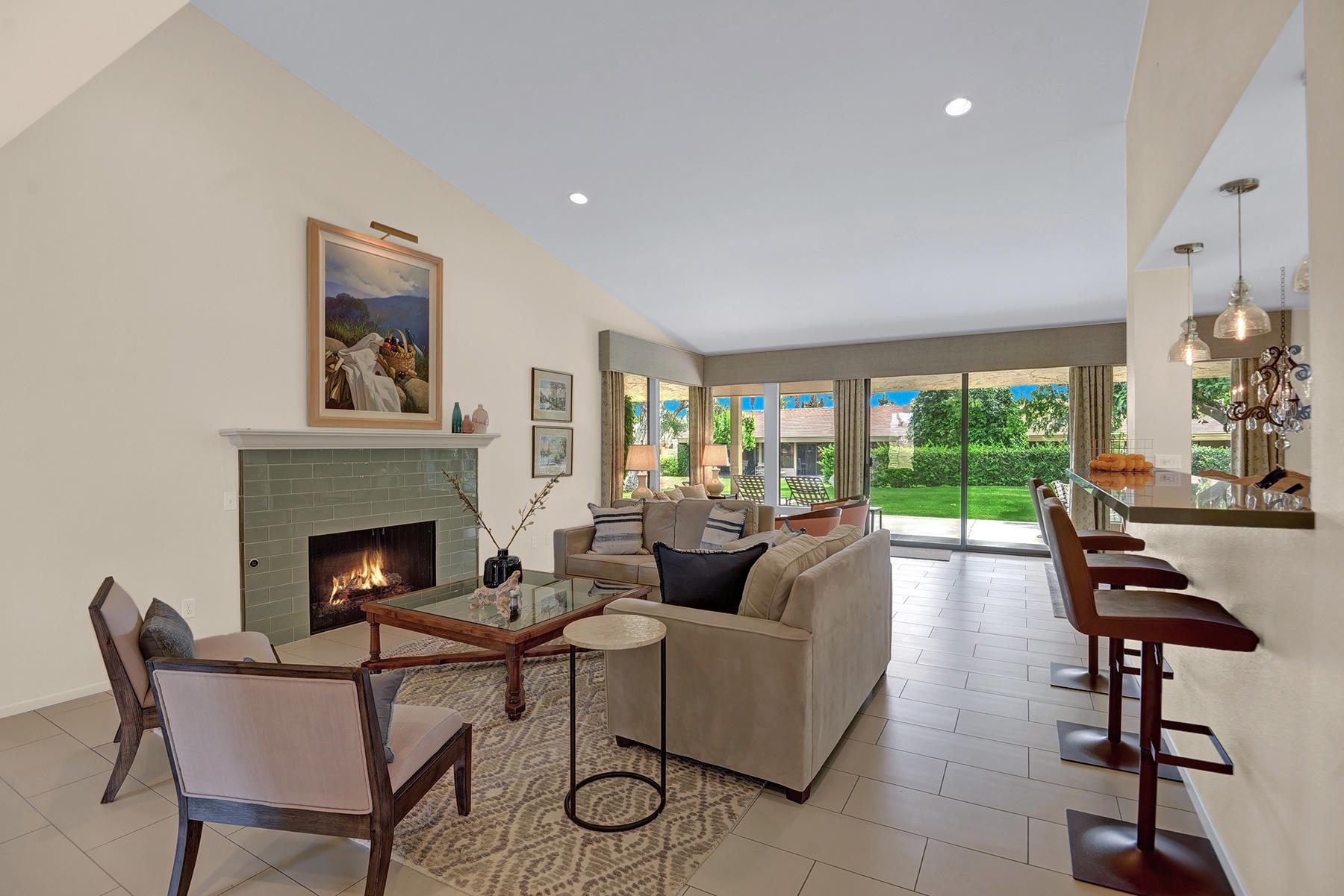 a living room with furniture a fireplace and a floor to ceiling window