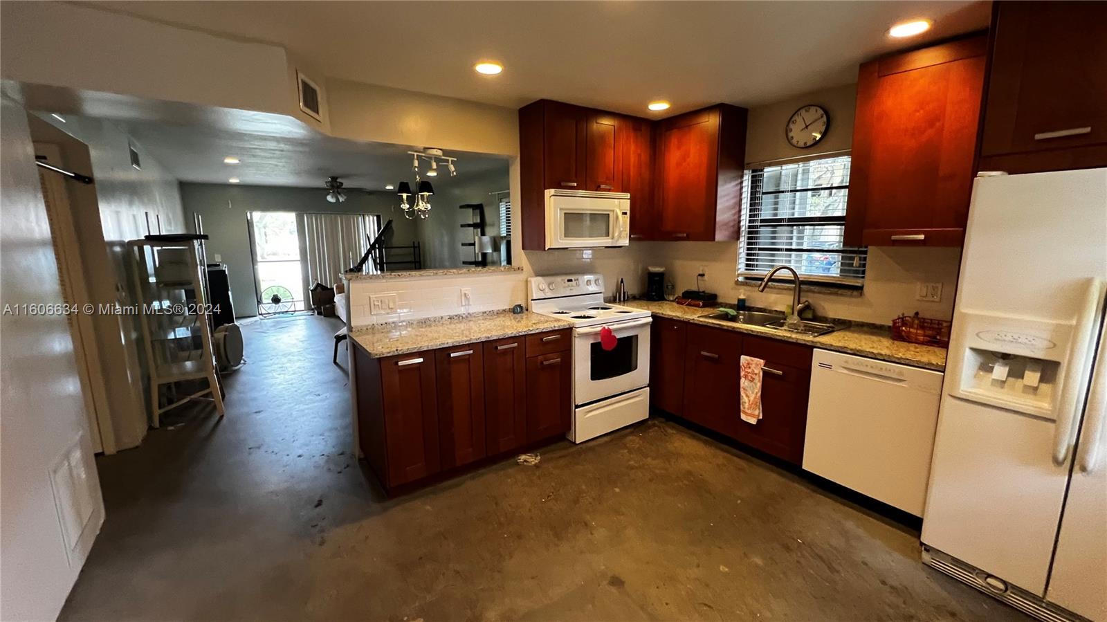 a large kitchen with stainless steel appliances granite countertop a large counter top a stove and a refrigerator