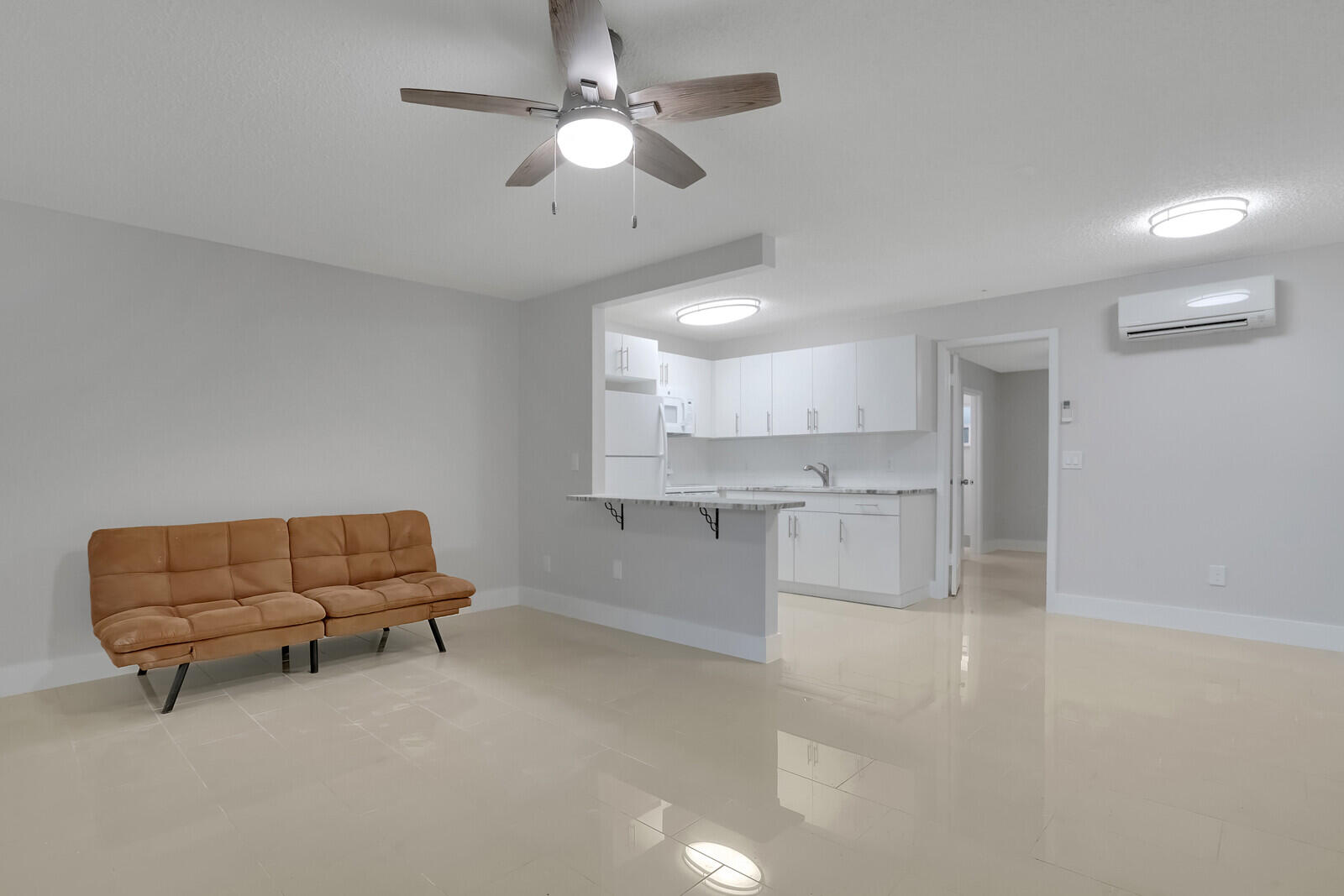 a living room with furniture and a ceiling fan