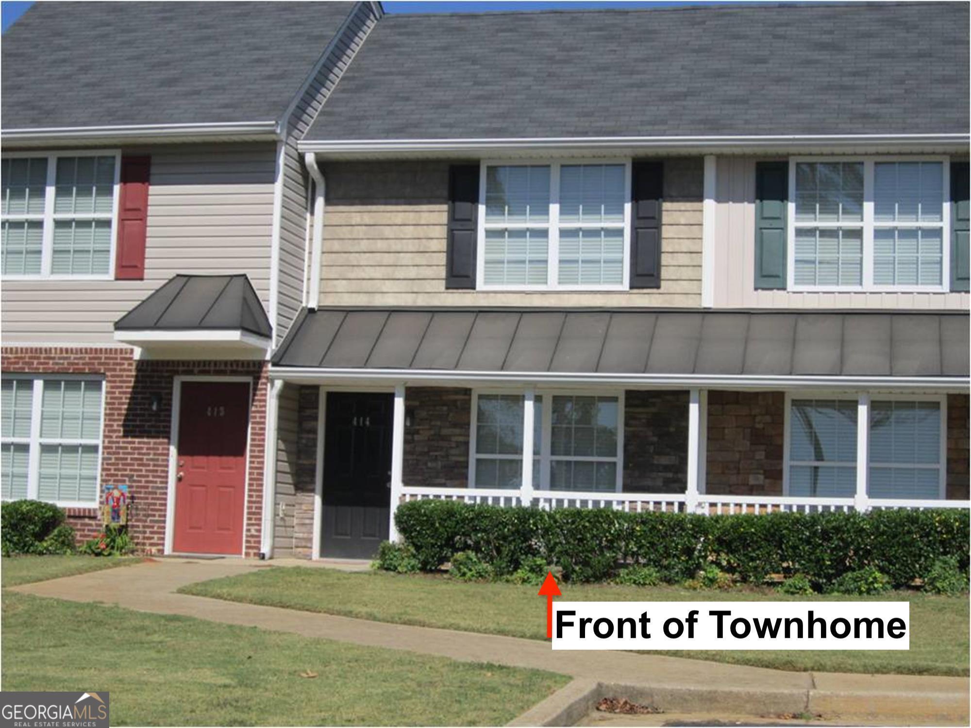 front view of a brick building with a yard