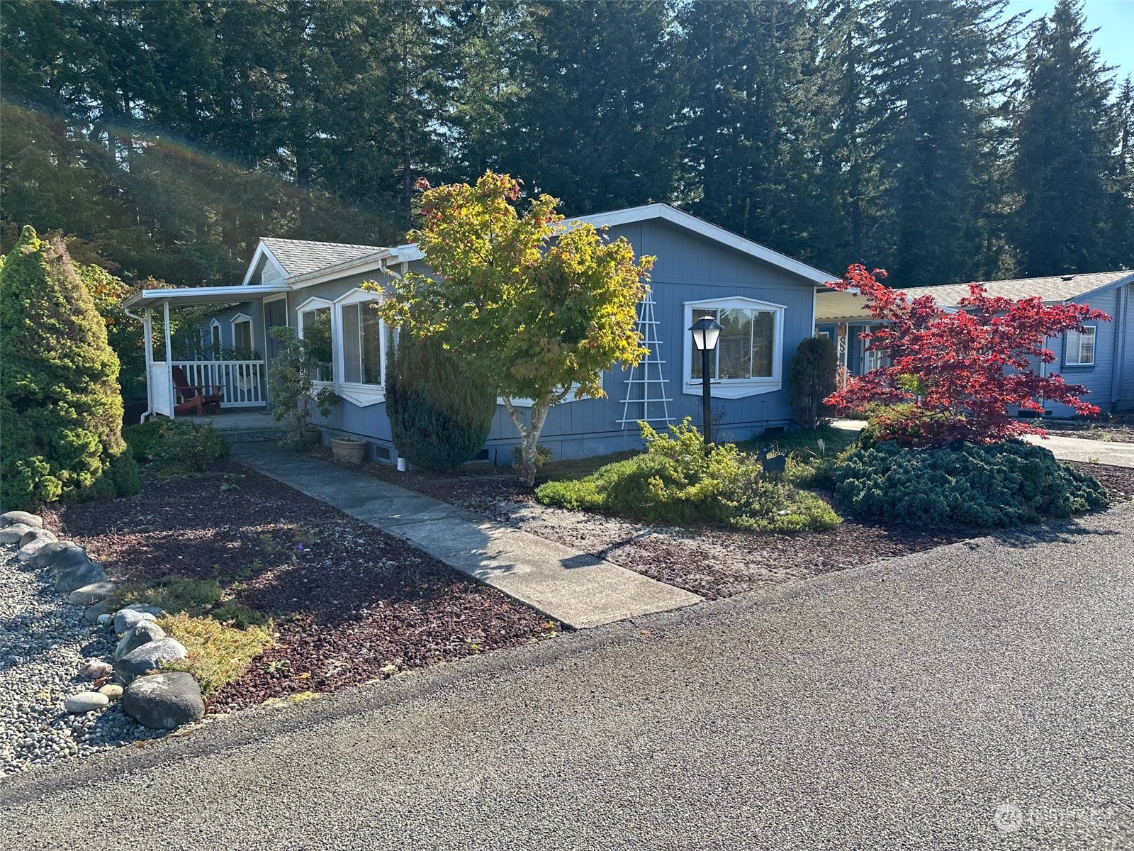 a front view of a house with a yard and a garden