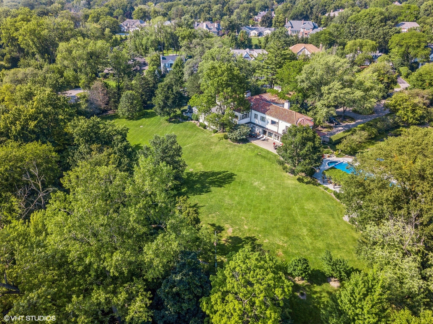 an aerial view of residential houses with outdoor space and trees